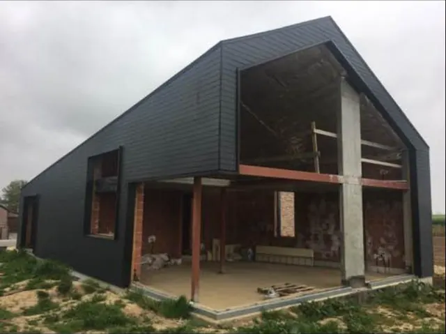 Extension cubique moderne en bardage noir avec brique apparente par KToit, architecture contemporaine Hainaut